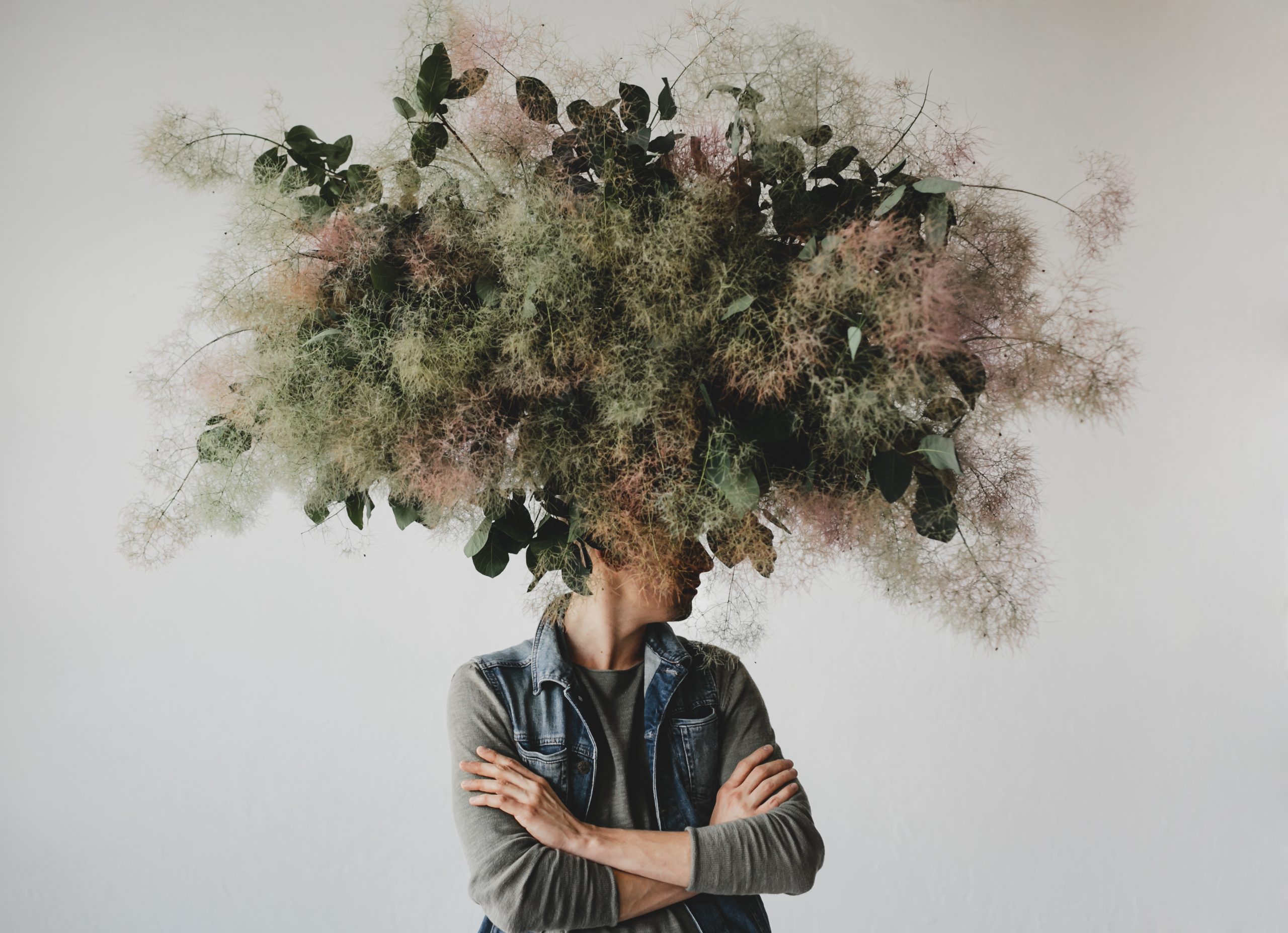 Portrait conceptuel d’une personne dont la tête est remplacée par un grand bouquet végétal aux textures aériennes