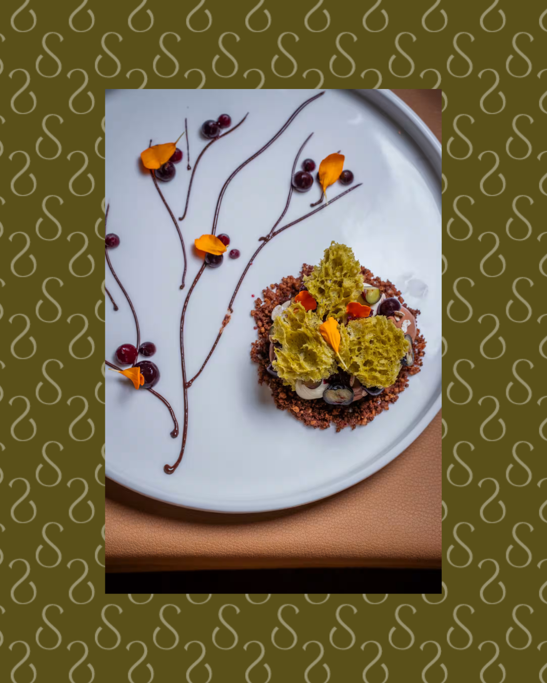 Dessert gastronomique du restaurant Mensa avec tuile croustillante verte, fruits rouges et décor chocolat sur assiette blanche