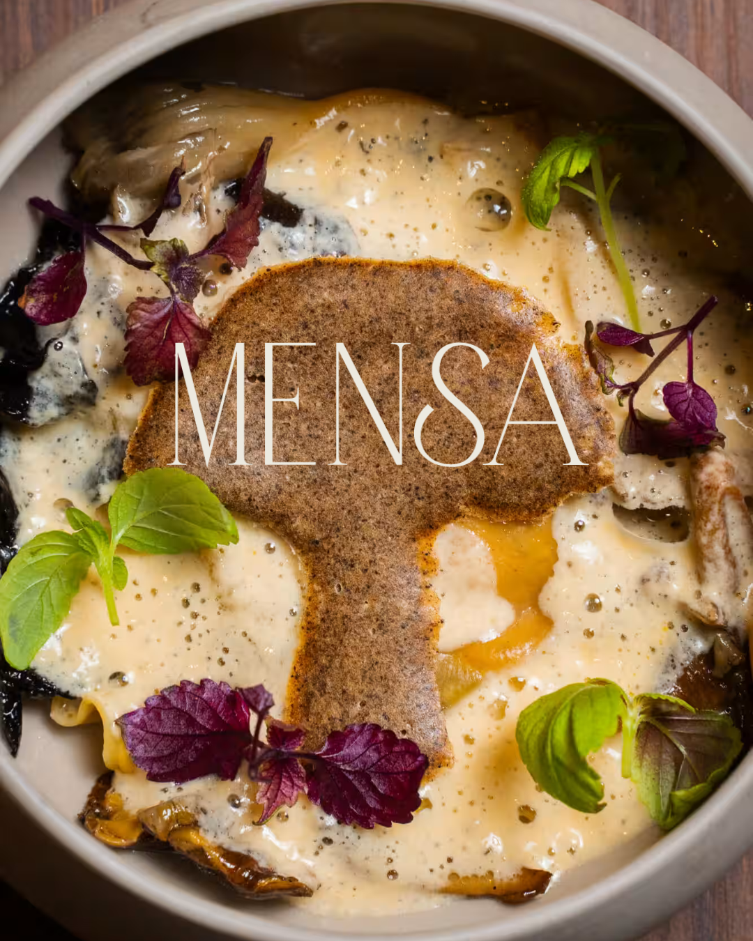 Plat crémeux aux champignons et herbes fraîches surmonté d'une tuile en forme de champignon, logo Mensa incrusté