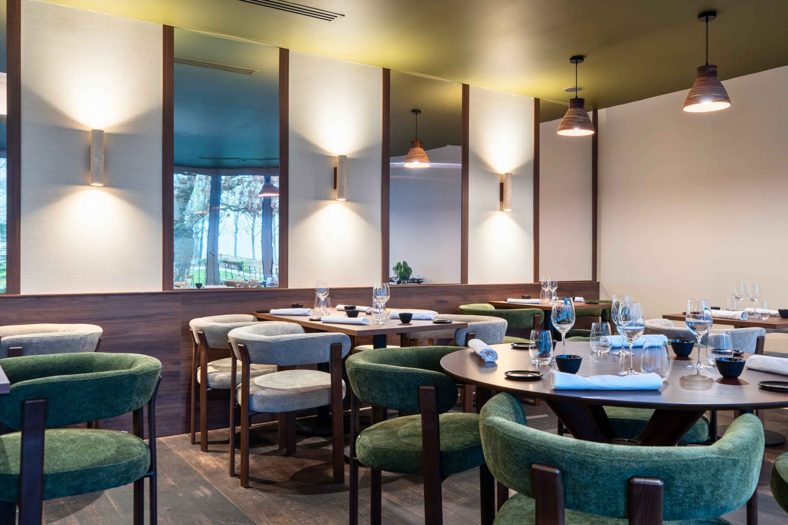 Salle de restaurant gastronomique Mensa à Tours avec habillage bois, miroirs verticaux et éclairage mural – architecture intérieure