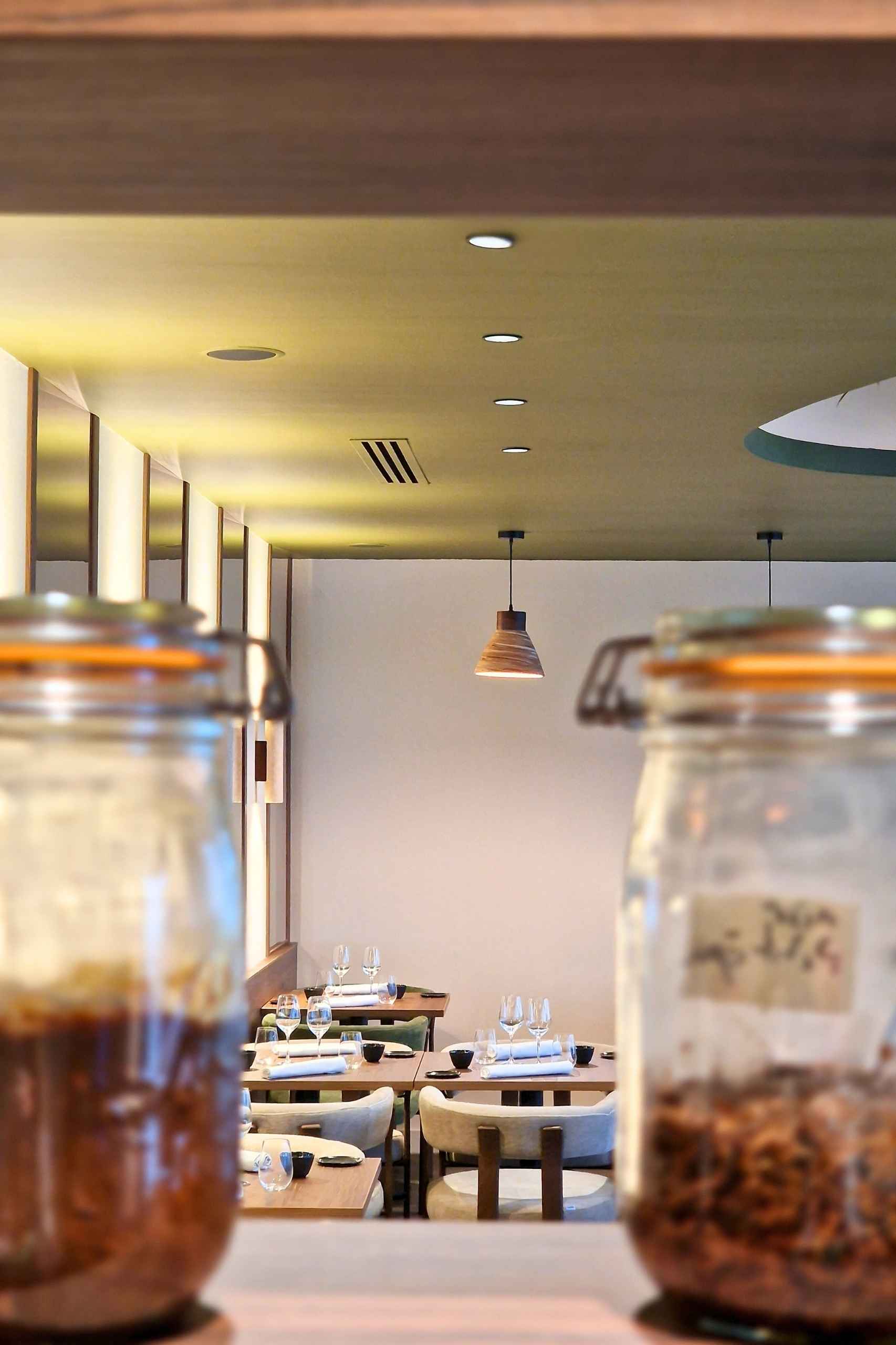 Bocaux de fermentation exposés en salle restaurant Mensa Tours – design global et narration culinaire