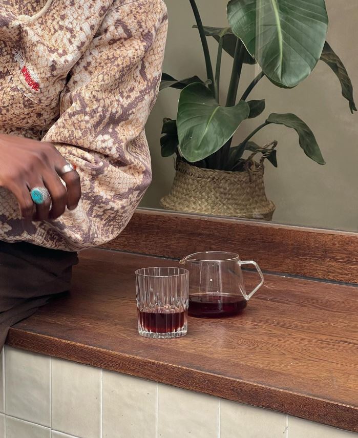 Banquette en bois sous vitrine avec verre de boisson dans coffee shop parisien