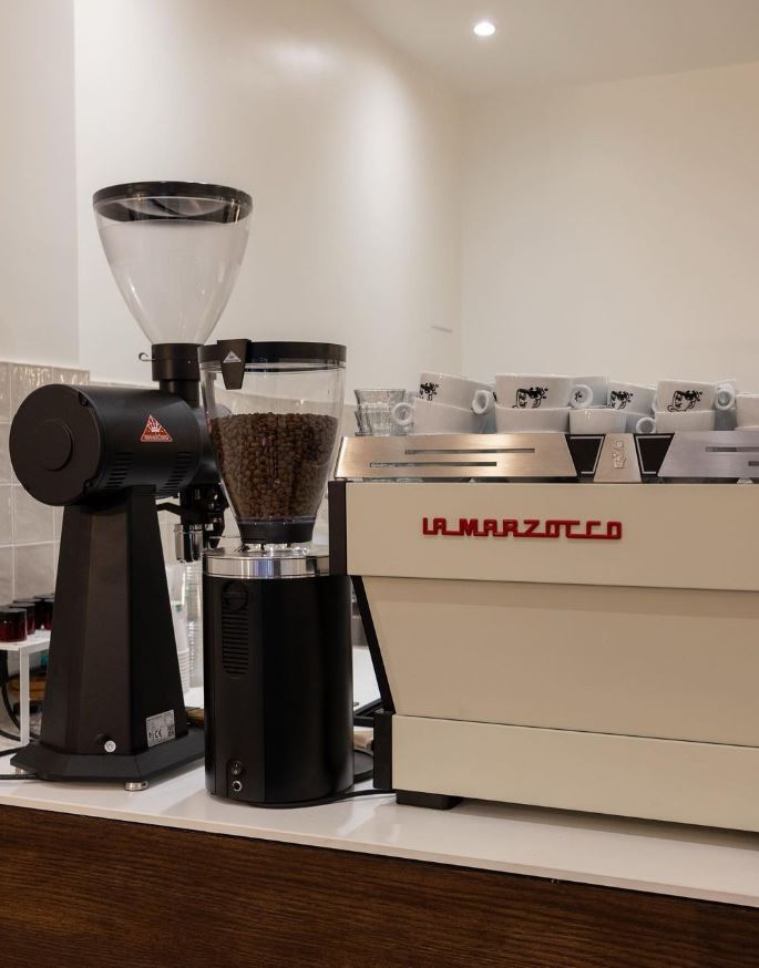 Machine La Marzocco sur comptoir de coffee shop minimaliste