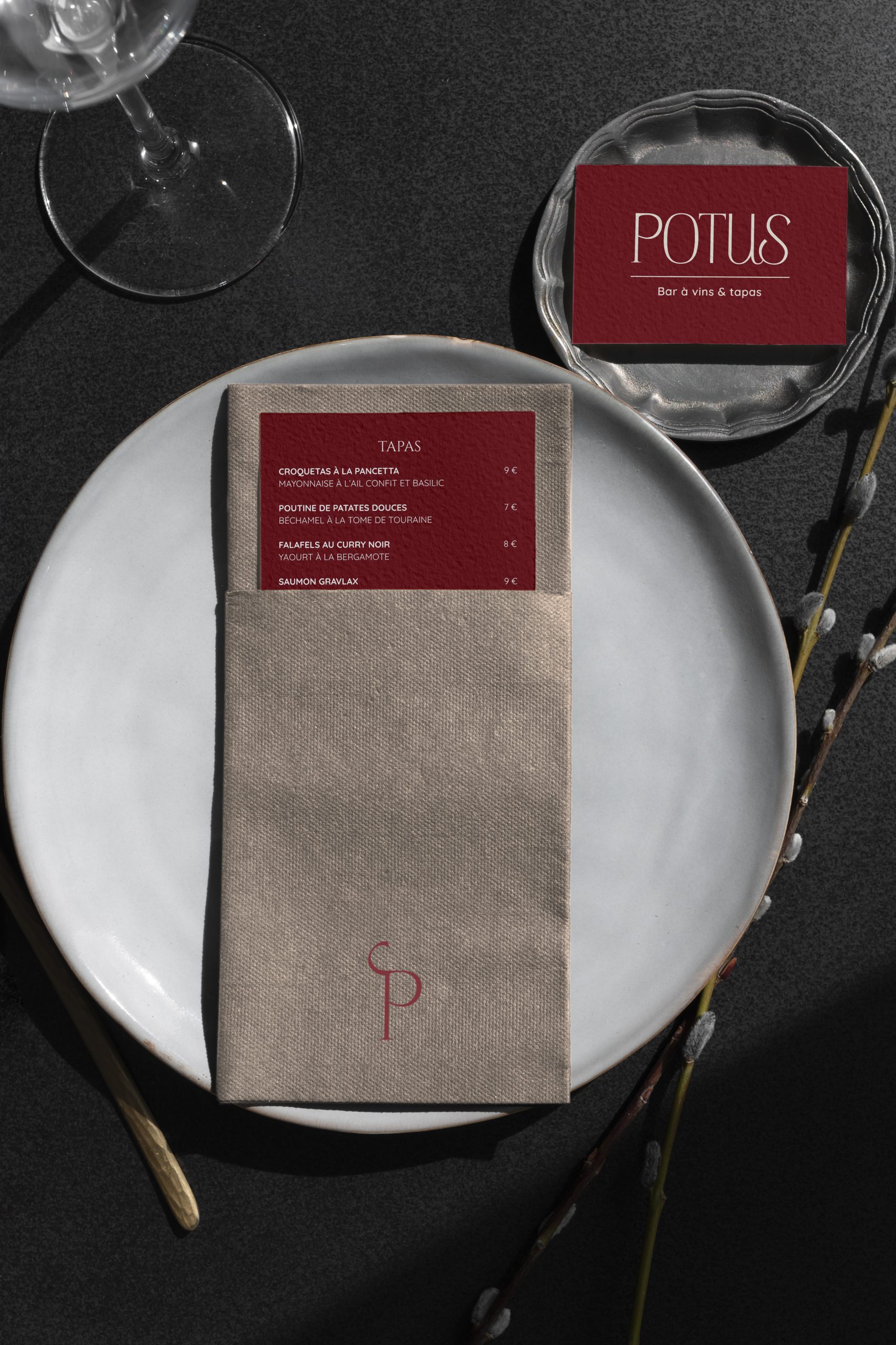Carte tapas du bar à vins POTUS présentée sur une assiette avec serviette monogrammée