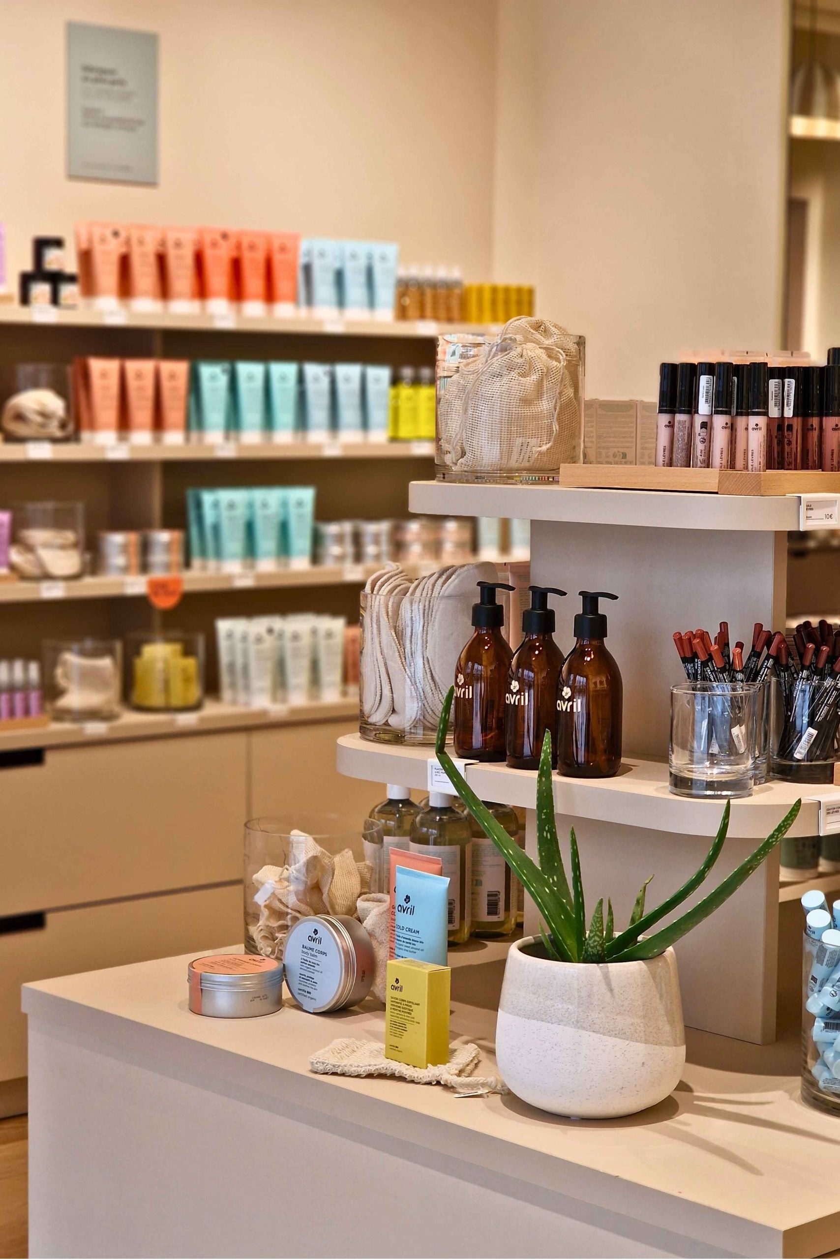 Linéaire mural de présentation des cosmétiques bio Avril, conçu pour une lecture claire des gammes et une ergonomie de consultation en boutique.
