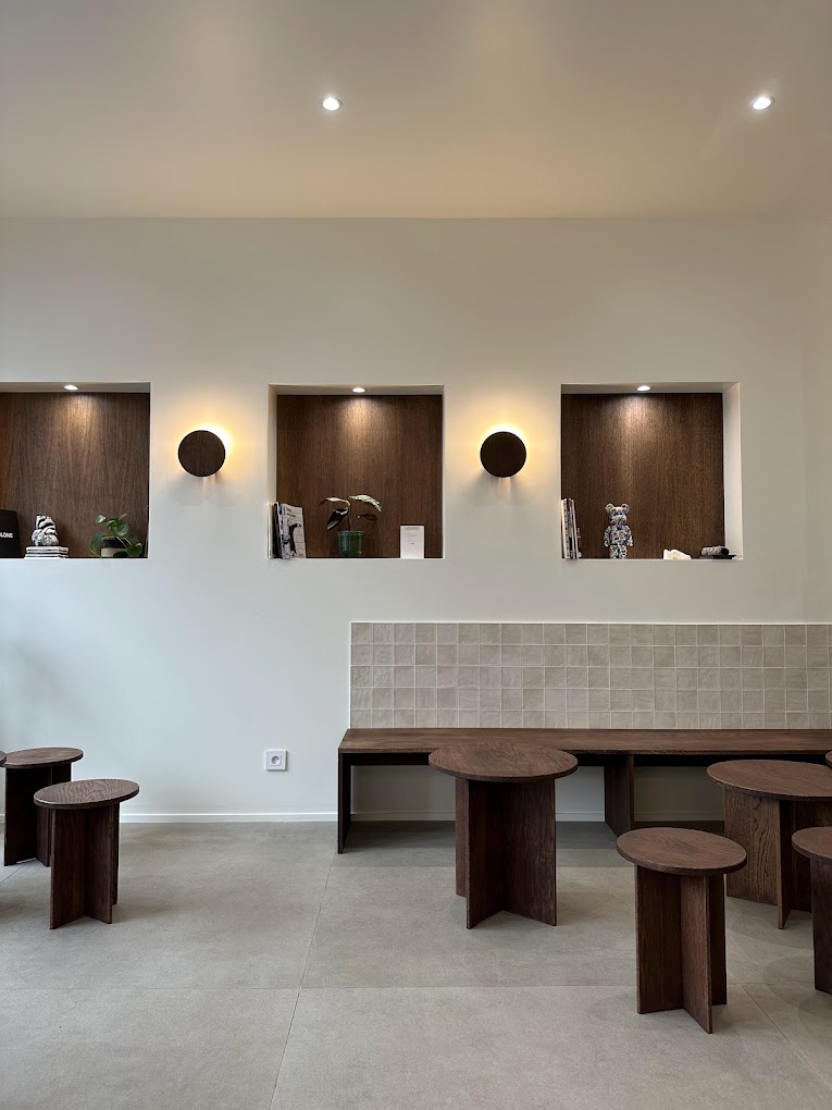Mur avec niches éclairées et banquette intégrée dans coffee shop minimaliste