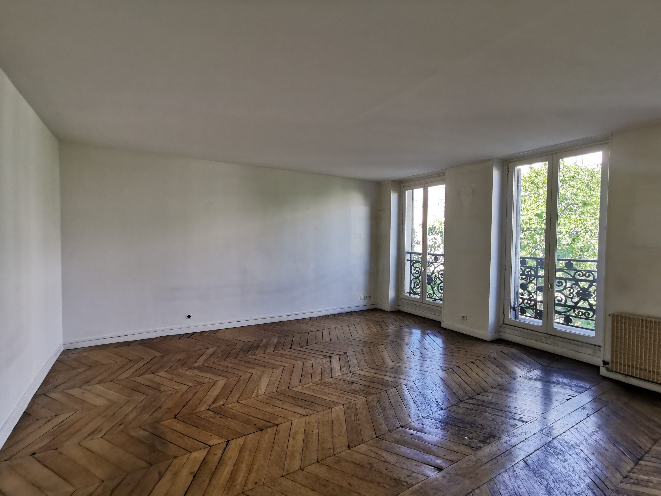 Salon ancien avec parquet bois avant rénovation à Paris