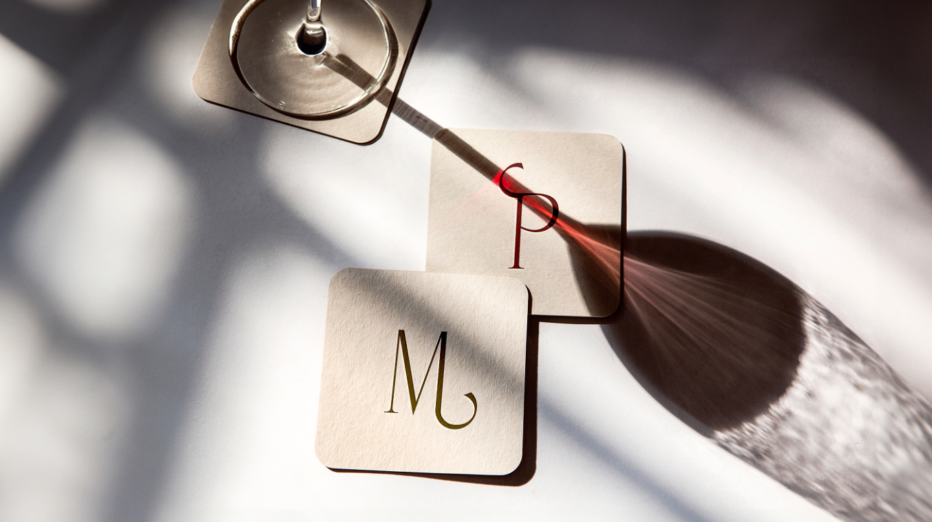 Sous-verres avec monogrammes M et P sous un verre de vin