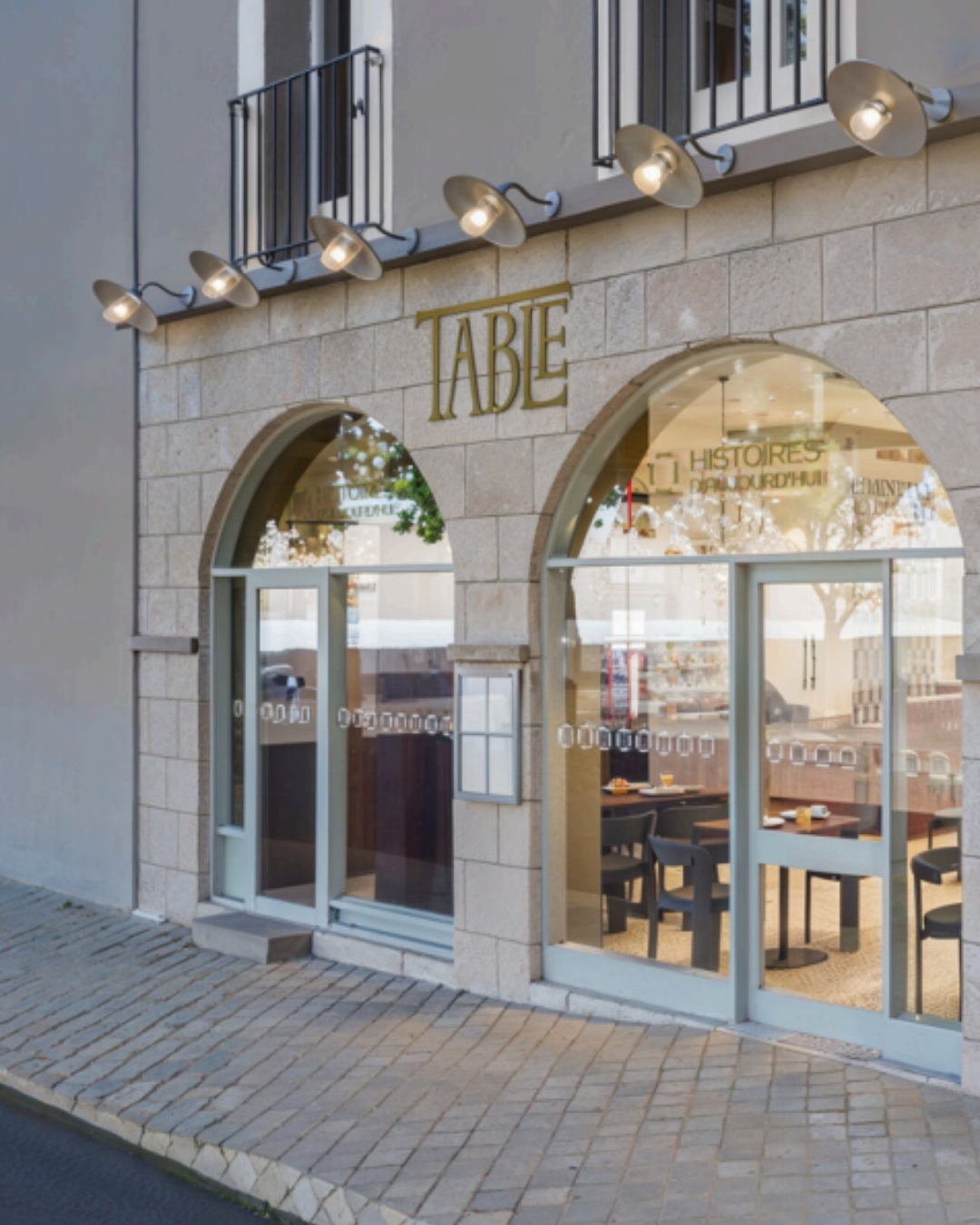 Façade en pierre du restaurant Table à Blois avec enseigne dorée et vitrines arquées ouvrant sur la salle